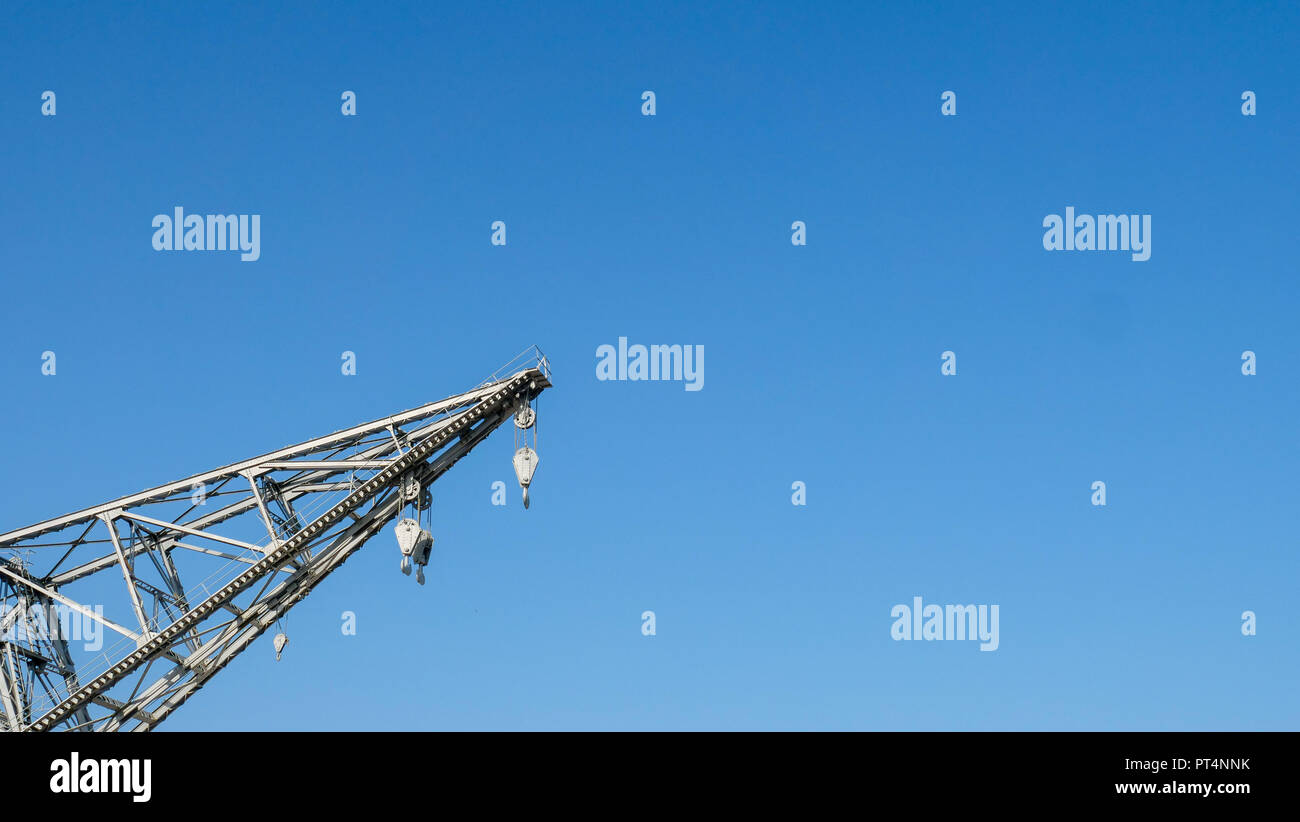 Detail einer alten Hafen Kran mit Riemenscheibe und Haken in einem klaren blauen Himmel Stockfoto