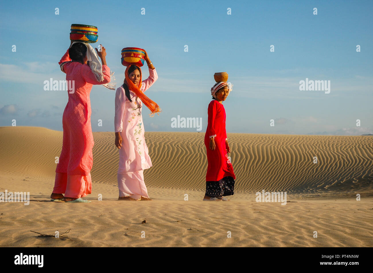 Phan Rang, Vietnam - Oktober 1, 2005. Cham Frauen in traditioneller Kleidung zu Fuß über den Nam Cuong Sanddünen in der Nähe von Phan Rang Stockfoto