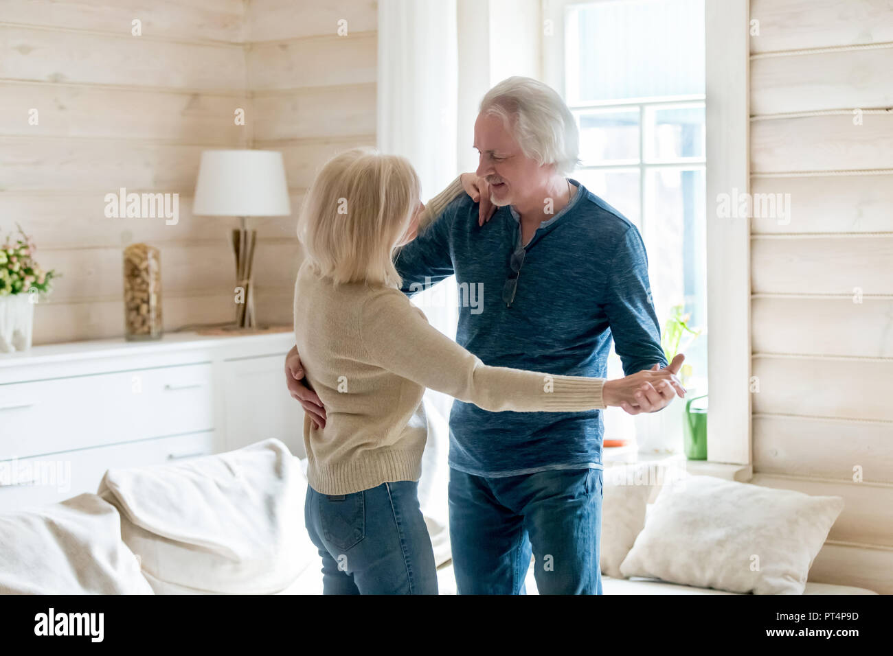Glücklich liebende Reifes Paar tanzen zu Hause im Wohnzimmer Stockfoto