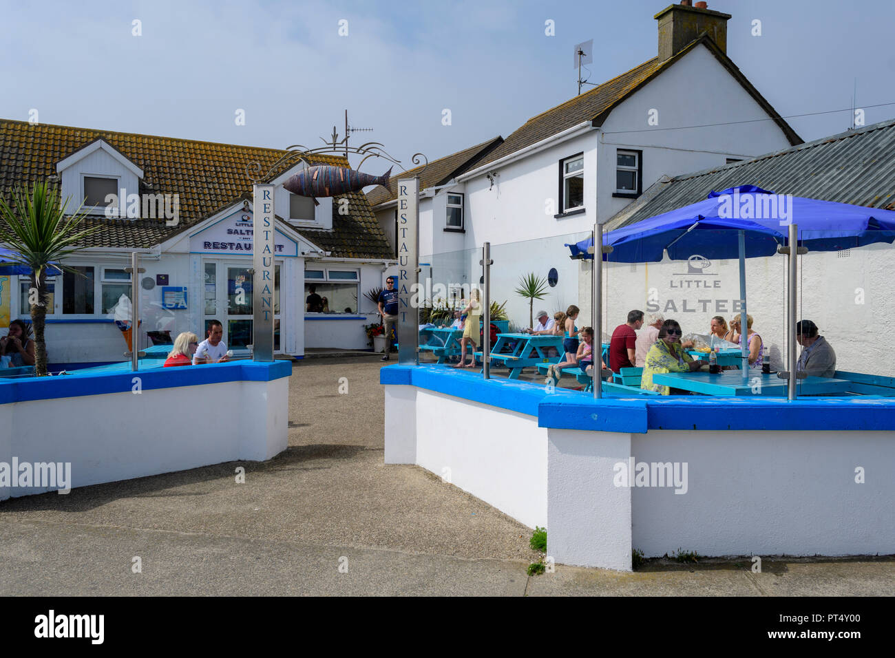 Touristen auf der Terrasse an einem sonnigen Sommer mit wenig Saltee Restaurant in Kilmore Quay, Irland Stockfoto