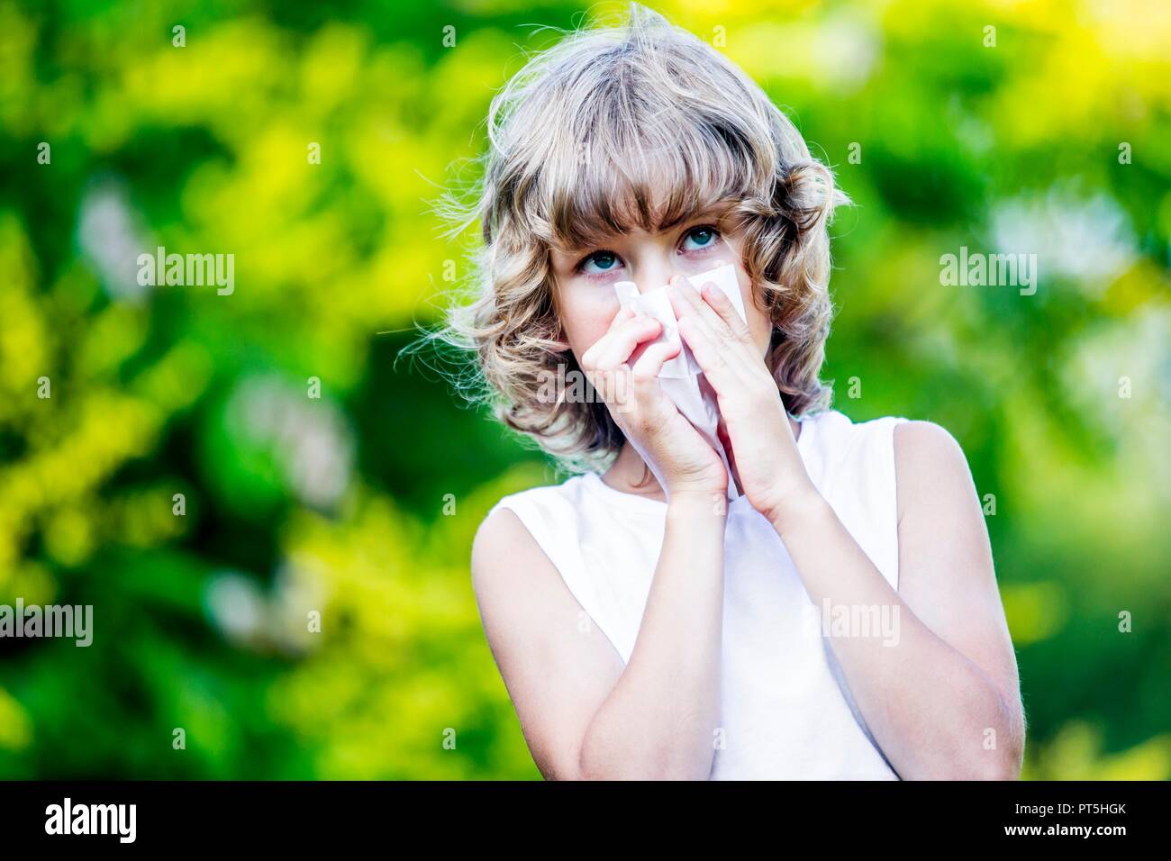 Junge bläst seine Nase in Park. Stockfoto