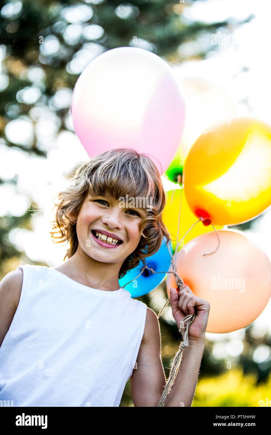 Junge holding Bündel Ballone im Park. Stockfoto
