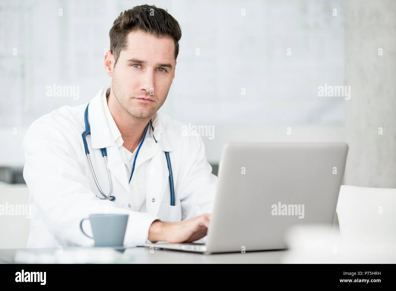 Portrait von ausgewachsenen männlichen Arzt mit Laptop. Stockfoto