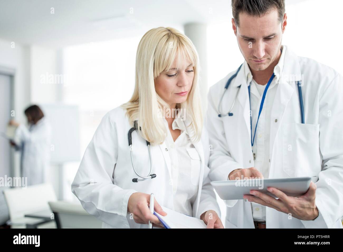 Männliche und weibliche Ärzte Prüfung digital Tablet. Stockfoto