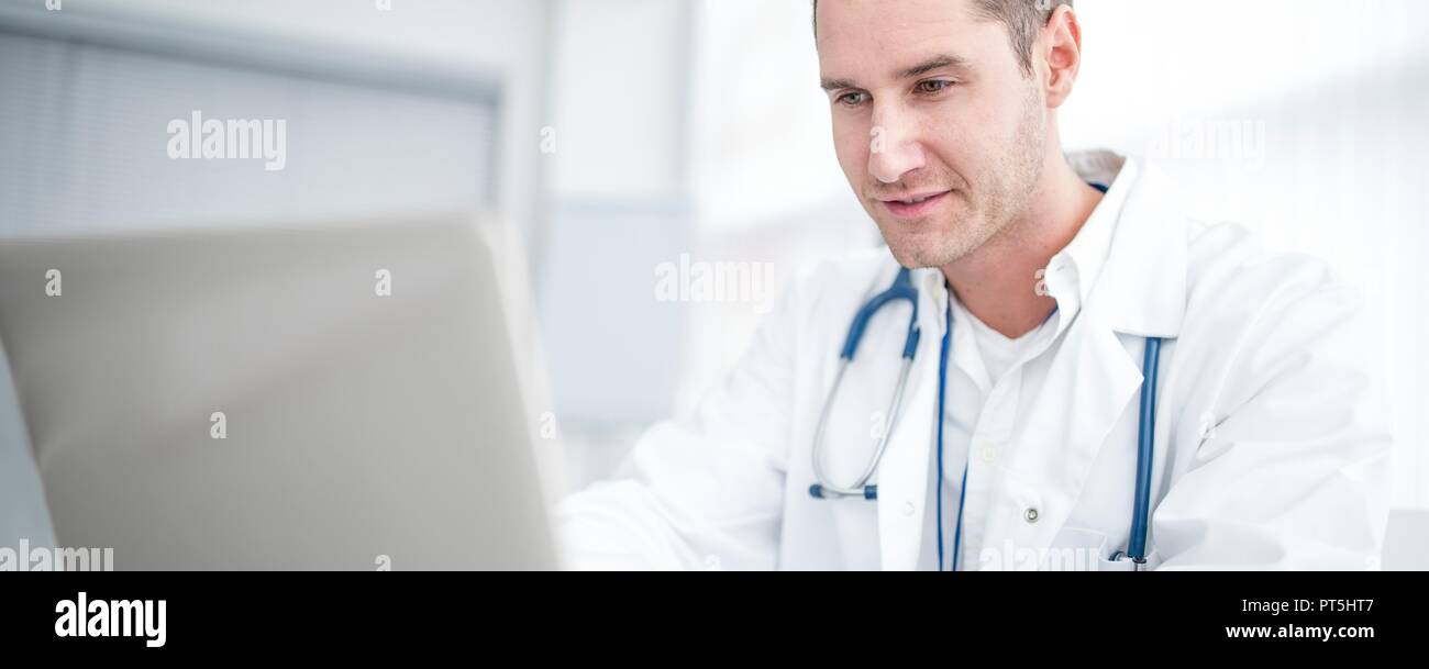 Männlicher Arzt mit Laptop und Konzentration. Stockfoto