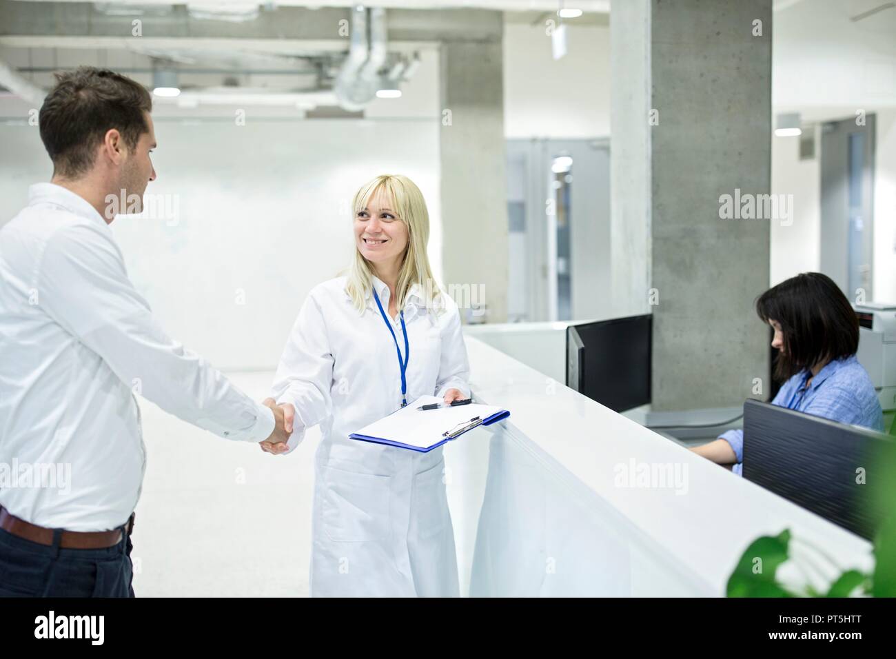 Ärztin Händeschütteln mit männlichen Patienten im Krankenhaus. Stockfoto