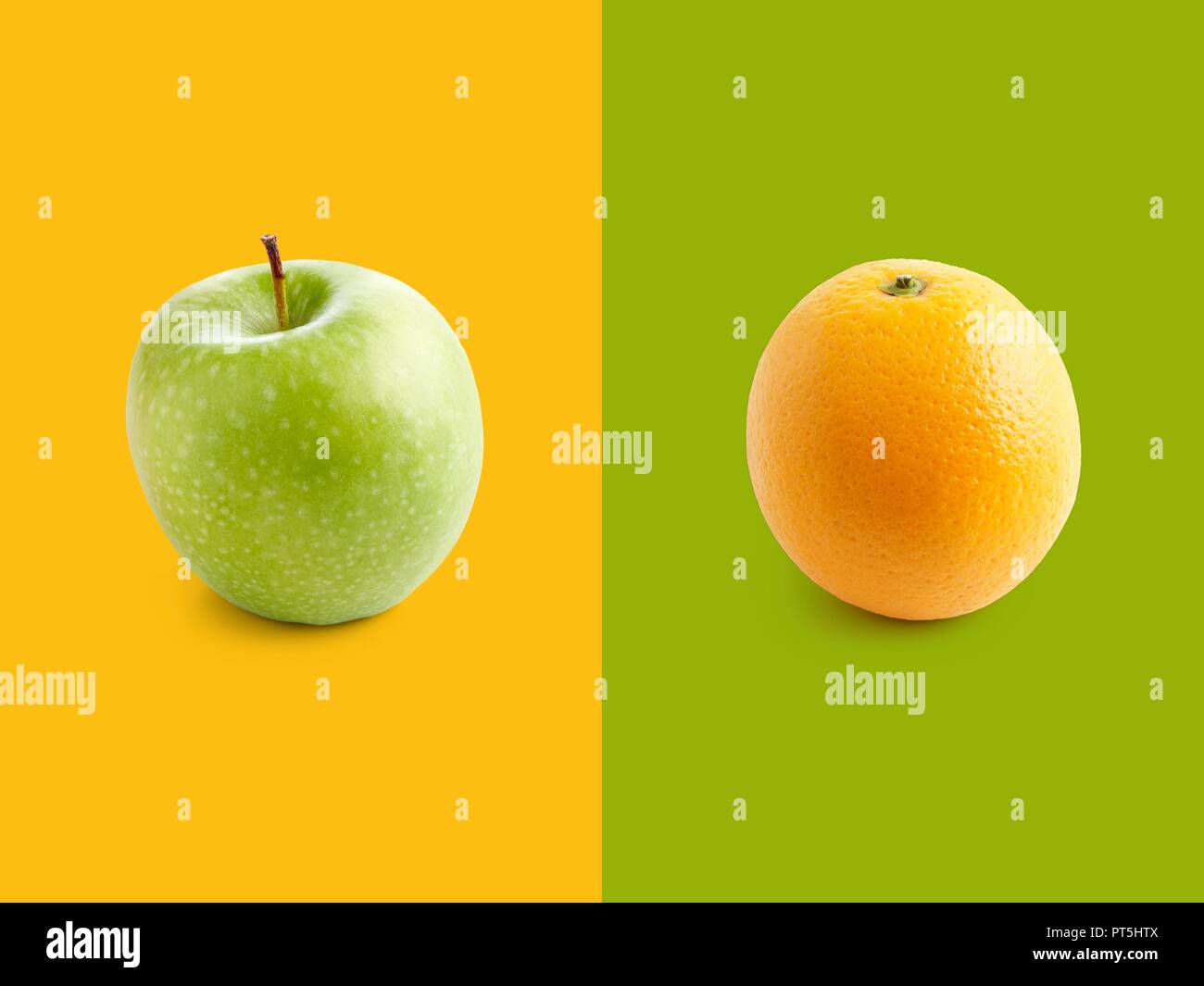 Apfel und Orange gegen gelben und grünen Hintergrund. Stockfoto