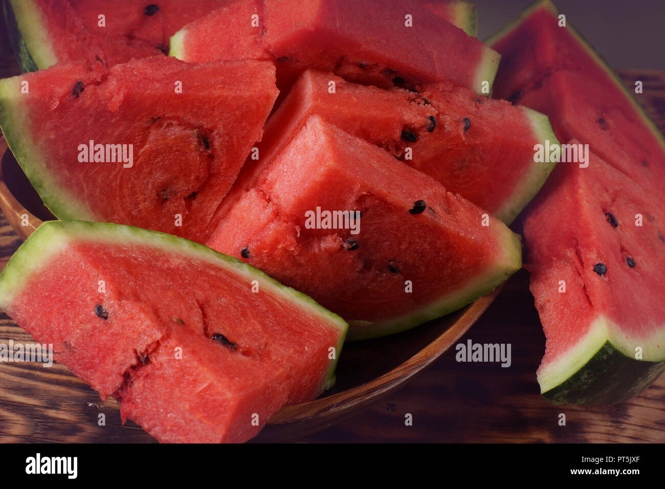 Saftige rote reife Wassermelone mit schwarzen kleinen Knochen in Scheiben schneiden, Tönen an den Rändern. Stockfoto