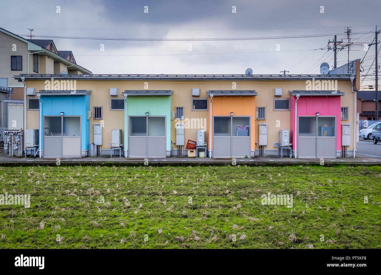 Gebäude mit 4 bunten Türen, mit kultiviertem Land im Vordergrund. Kanazawa, Japan, Winter. Stockfoto