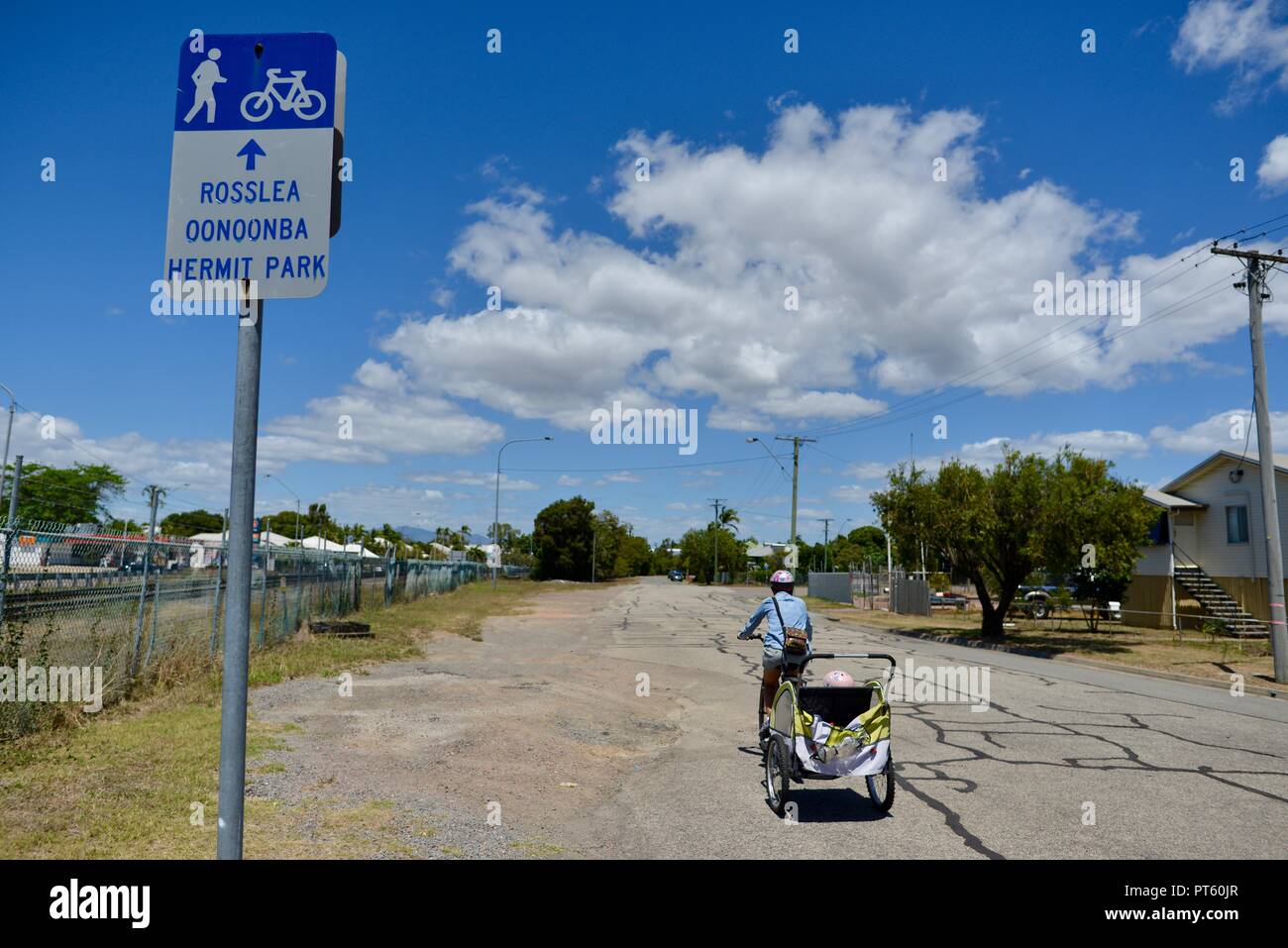 Frau auf einem Fahrrad mit einem Fahrradanhänger für Kinder, Townsville, QLD, Australien Stockfoto