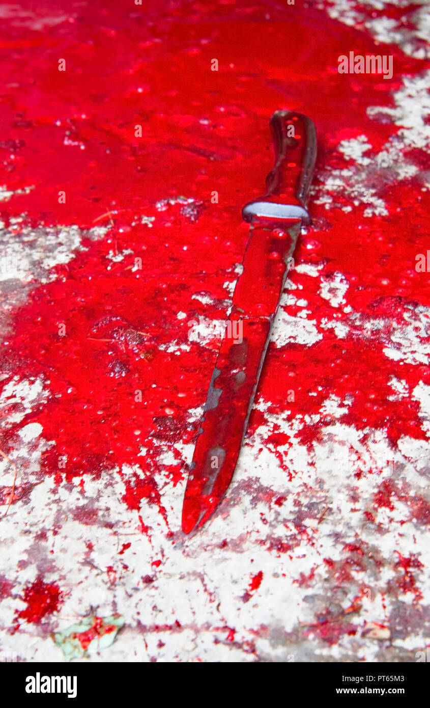 Konzeptionelle Bild von einem scharfen Messer mit Blut auf ihm ruht auf einem Betonboden. Konzept Foto von Mord und Verbrechen Stockfoto