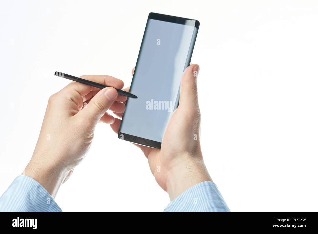 Mit Smartphone mit Stift in der Hand auf weißem Hintergrund Stockfoto