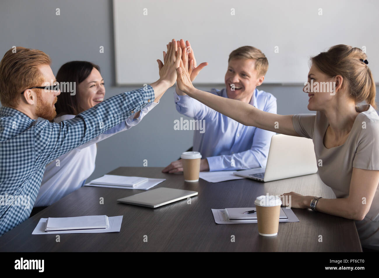 Aufgeregt Business Team von Mitarbeitern hoch fünf Während meeti Stockfoto