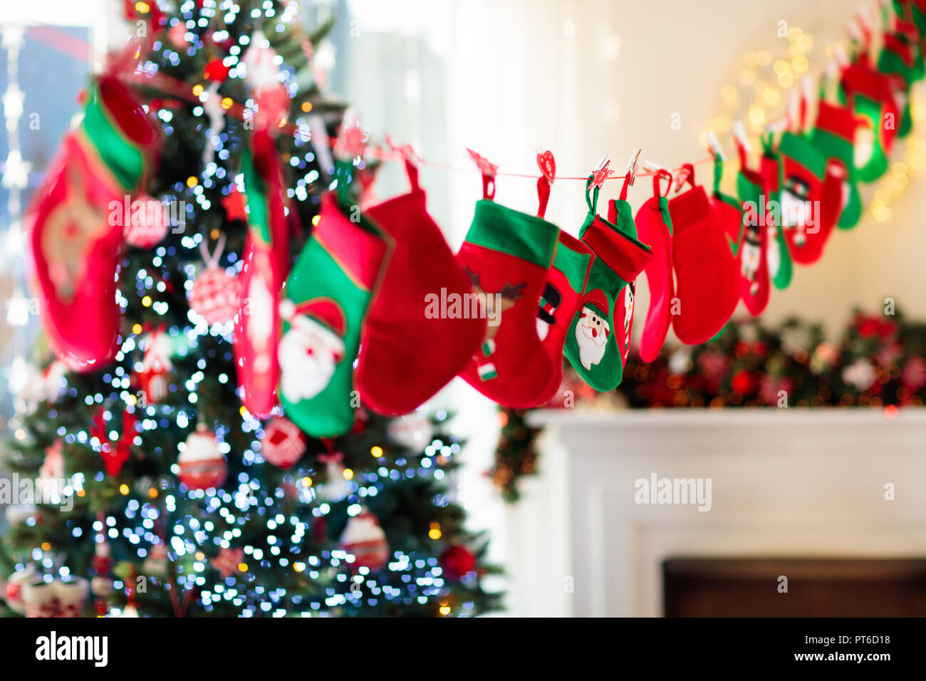 Weihnachtsgeschenke in grüne und rote Socken. Süßigkeiten und Geschenke in  kids Adventskalender auf Winter morgen. Geschmückten Weihnachtsbaum für  Familie mit Kinder Stockfotografie - Alamy