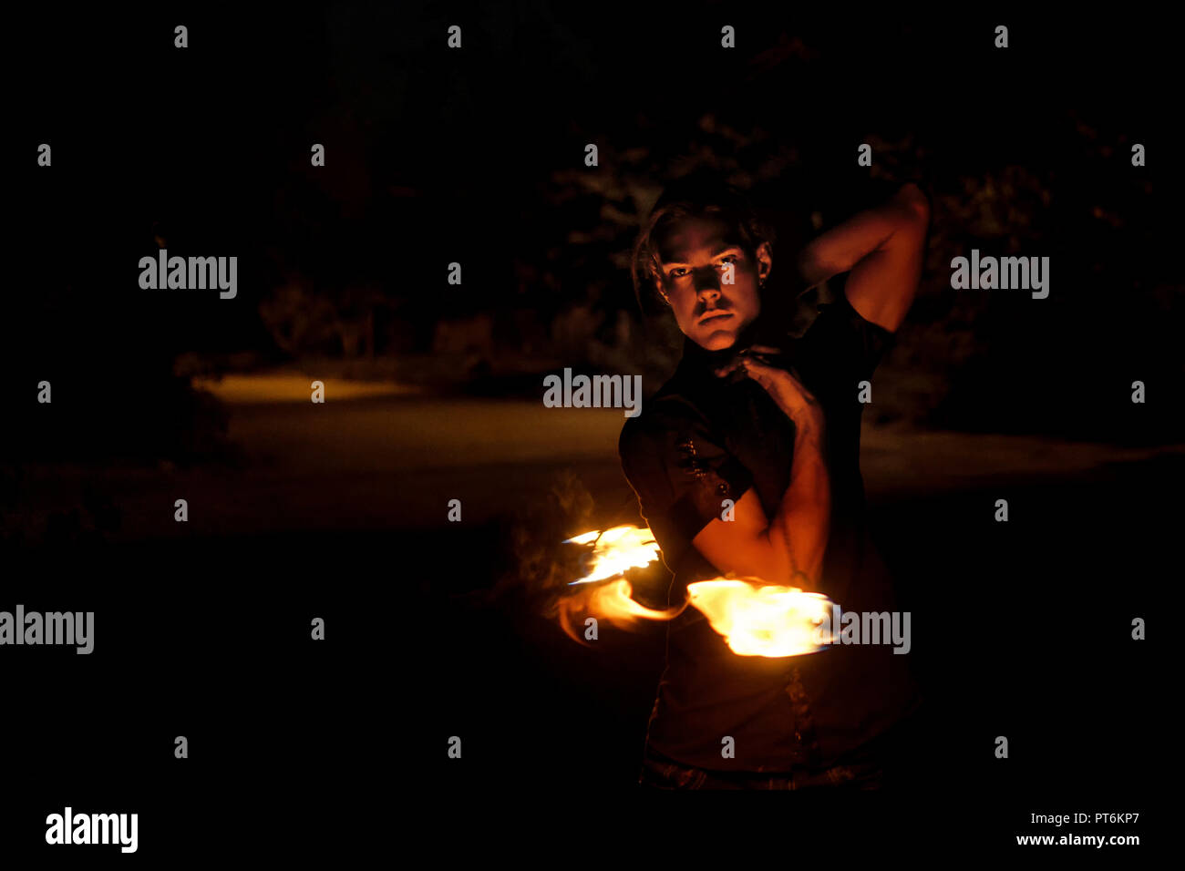 Feuer zeigen. Fakir jongliert mit Feuer Poi. Nacht Leistung. Dramatische portrait. Stockfoto
