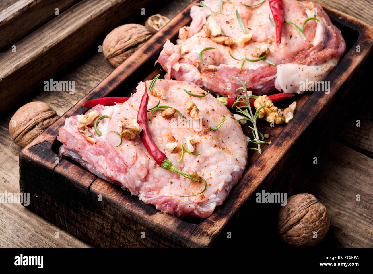 Rohen Steak auf einem Schneidebrett mit Pfeffer, Nussbaum. rohes Schweinefleisch. Stockfoto
