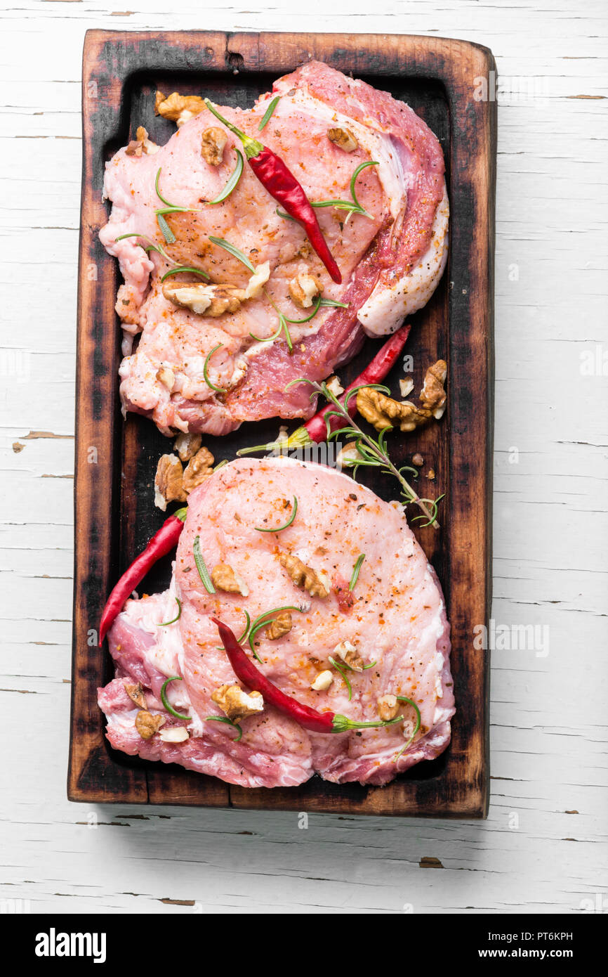 Rohen Steak auf einem Schneidebrett mit Pfeffer, Nussbaum. rohes Schweinefleisch. Stockfoto