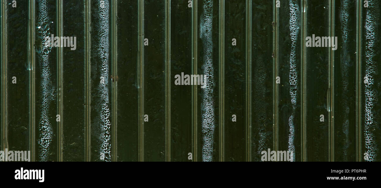 Schöne Textur beschlagene Glas, in Abschnitte unterteilt und Wassertropfen. Vertikale Linien aufteilen Hintergrund in Teile. Unter den rosa Streifen Stockfoto