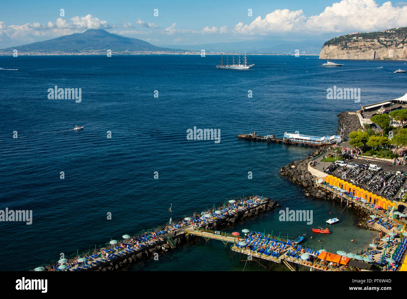 Vesuv in der Nähe von Sorrent auf einem hellen, sonnigen Tag mit Wolken und einem großen Segelschiff im Vordergrund. Stockfoto