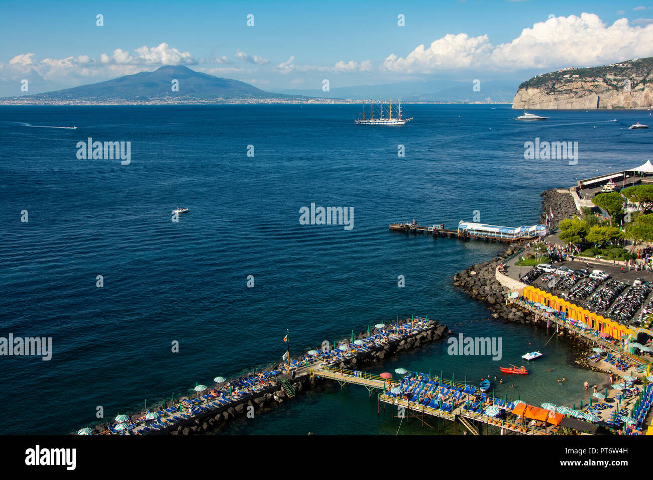 Vesuv in der Nähe von Sorrent auf einem hellen, sonnigen Tag mit Wolken und einem großen Segelschiff im Vordergrund. Stockfoto