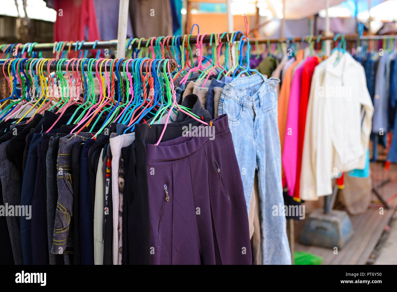 Hosen und Jeans auf Kleiderbügeln im Second hand Store Stockfoto