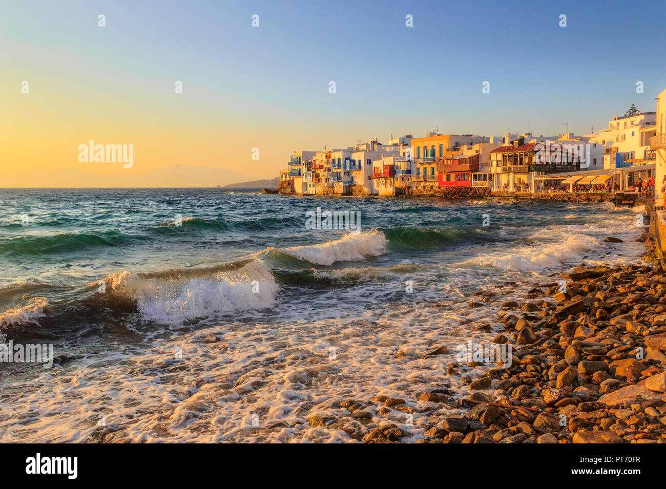 Sonnenuntergang Blick auf die berühmte malerische kleine Venedig auf der Insel Mykonos. Plätschernden Wellen über Bars und Restaurants in der Altstadt von Mykonos, Kykladen, Griechenland. Stockfoto