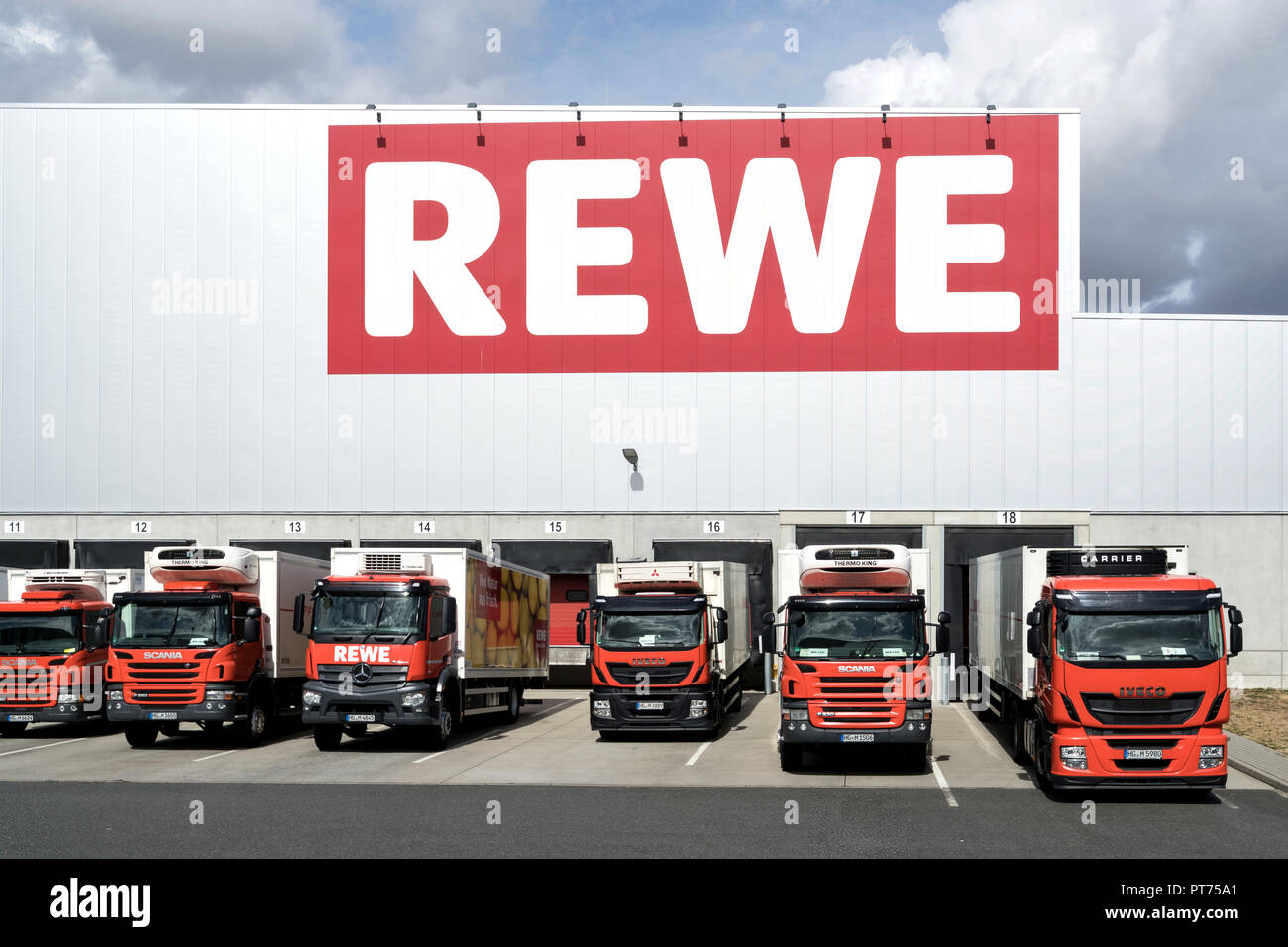 Nutzfahrzeuge bei REWE distribution center. REWE betreibt rund 3.300 Supermärkte in Deutschland. Stockfoto