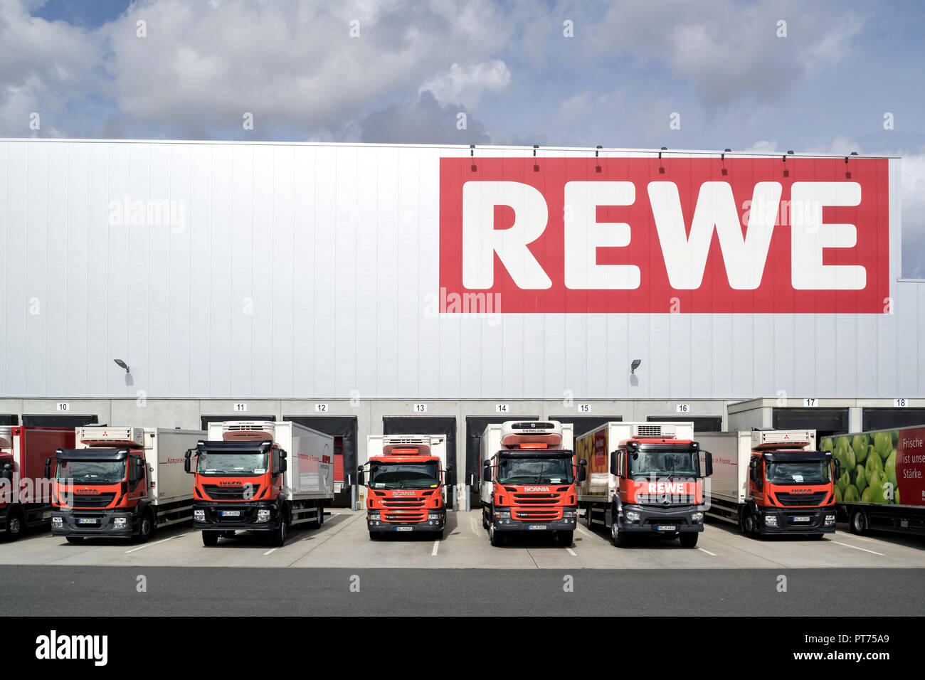 Nutzfahrzeuge bei REWE distribution center. REWE betreibt rund 3.300 Supermärkte in Deutschland. Stockfoto