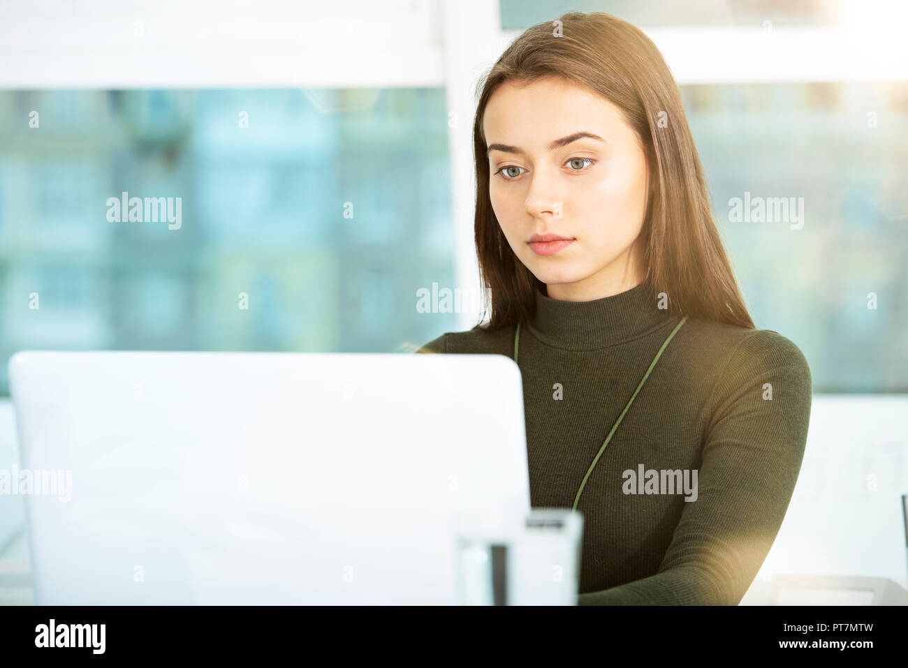 Mädchen arbeitet auf einem Laptop im Büro Stockfoto