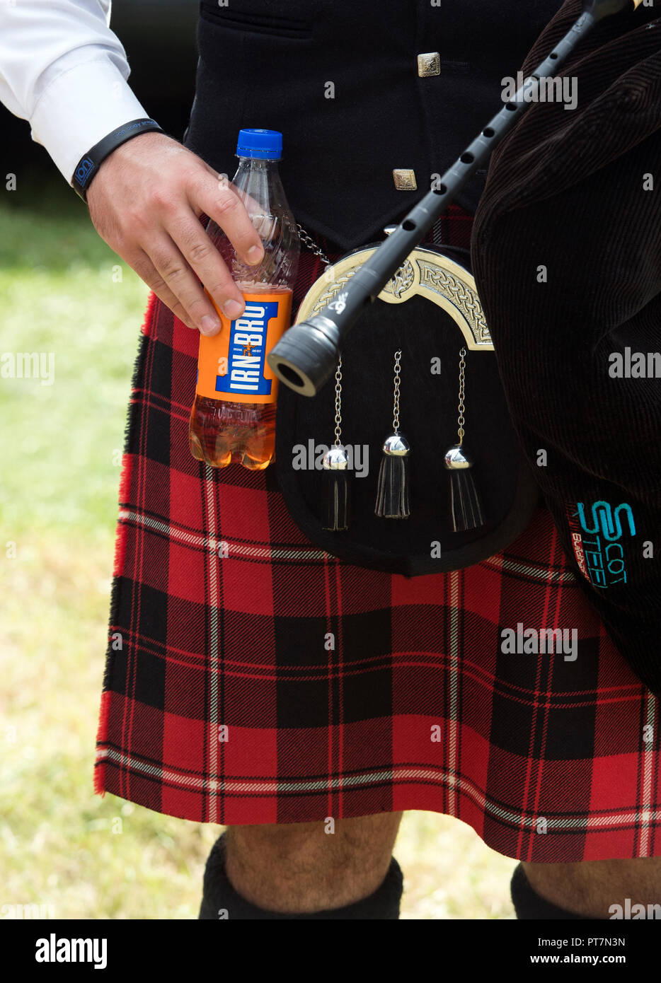 Scottish Bagpiper macht Pause und hält eine Flasche Irn Bru Stockfoto