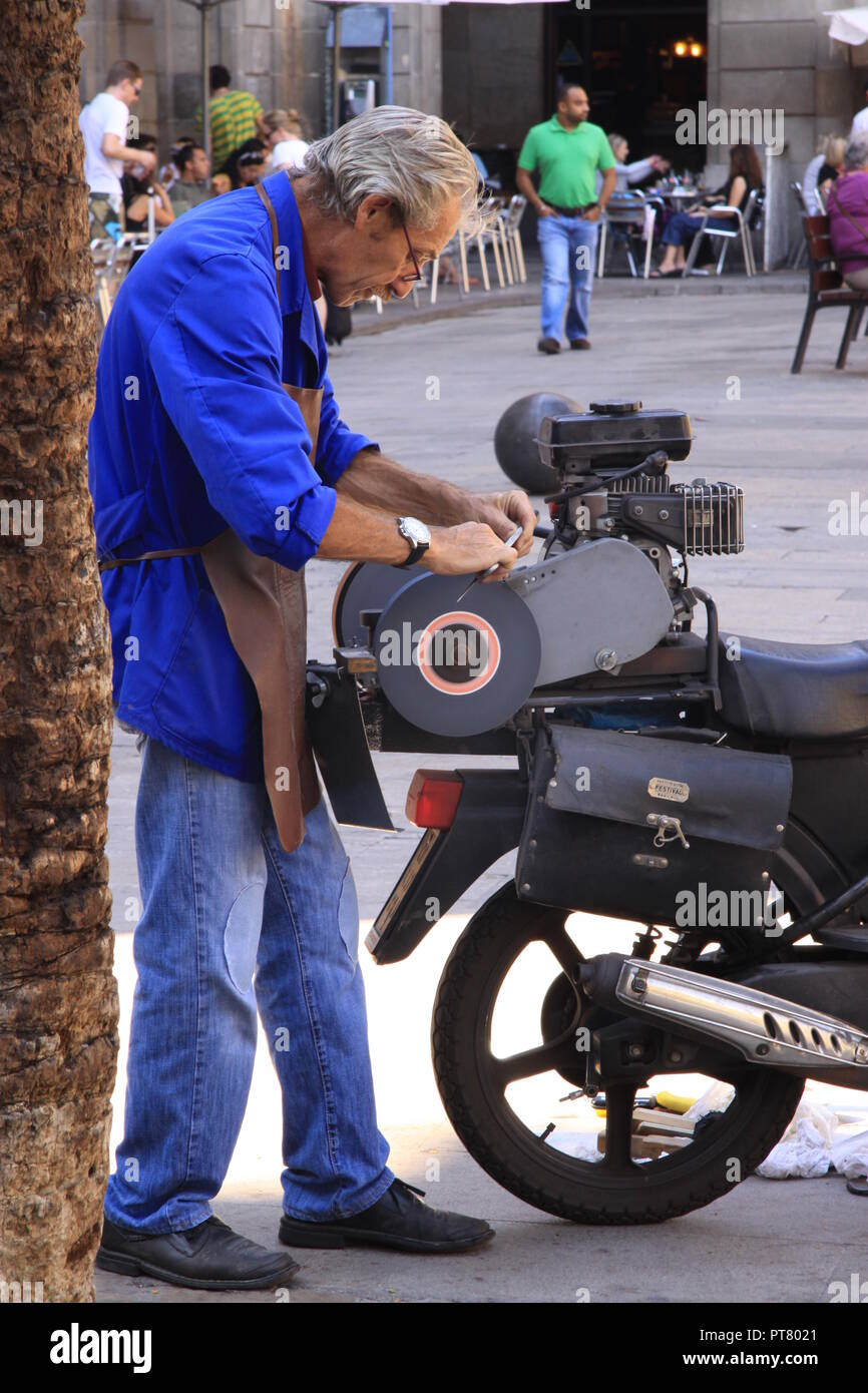 Mann Messerschärfer Schärfen der Messer auf einem schleifstein von hinten von einem Moped auf der Las Ramblas Barcelona Spanien Stockfoto