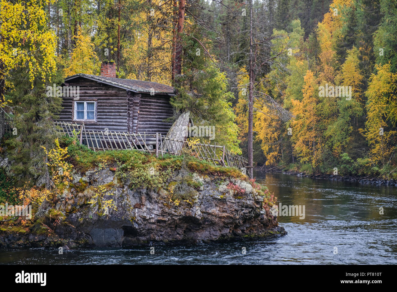 Schöne Herbstfarben mit Kabine und Fluss im Herbst Tag in Myllykoski, Kuusamo, Finnland Stockfoto