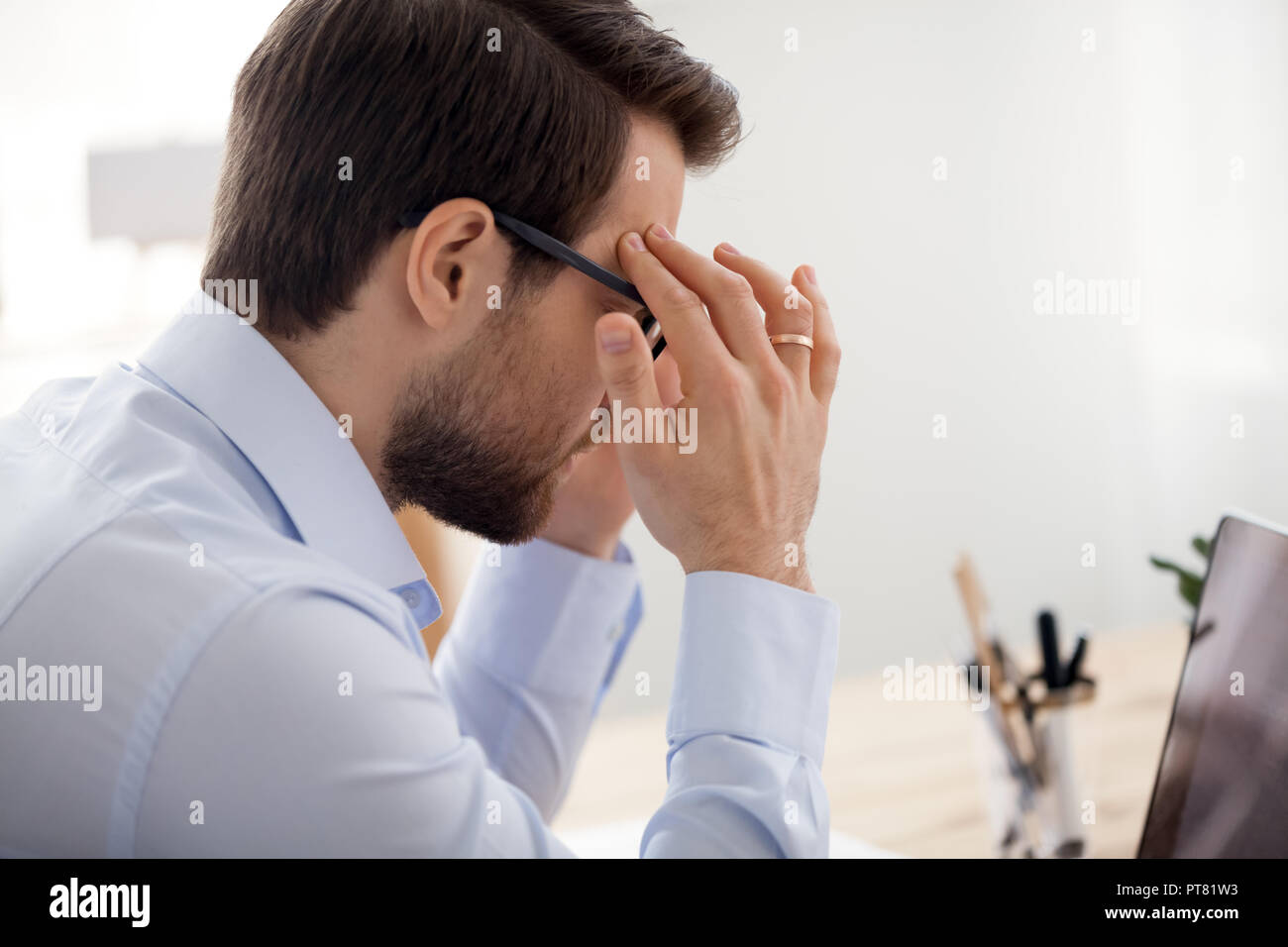 Ermüdet Geschäftsmann mit Kopfschmerzen arbeiten im Büro Stockfoto