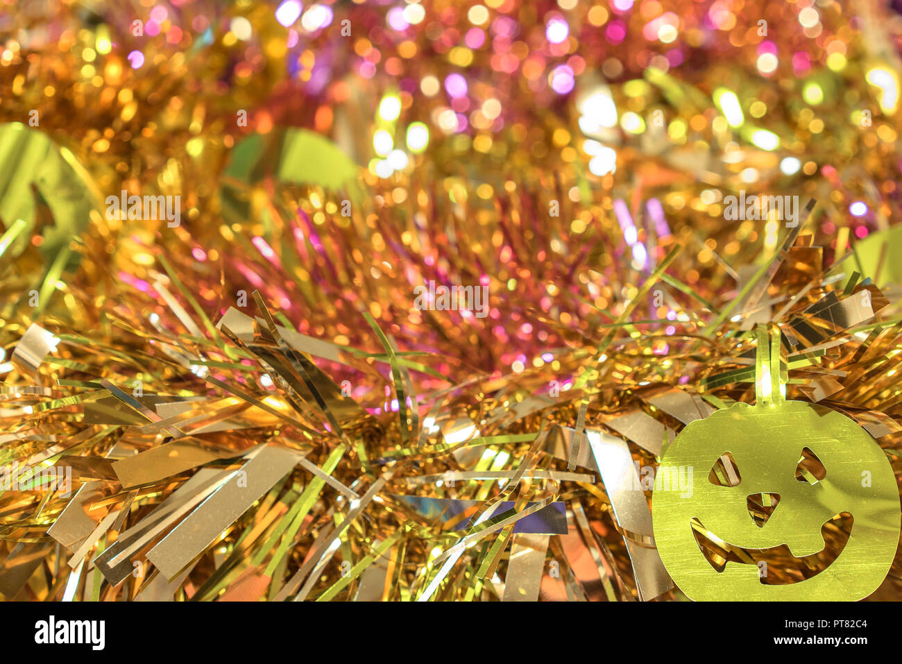 Hintergrund Textur voller goldener Bokeh mit Girlanden geschmückt von funny jack-o'-Lantern Kürbis lächelnde Gesichter Dekorationen zu Halloween. Stockfoto