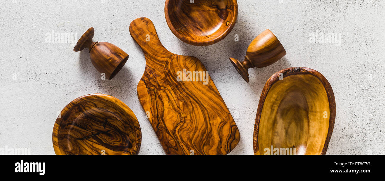 Banner der Holz- Utensilien aus dem Olivenbaum auf dem weißen Küche Tisch und die Zweige des Ölbaums. Umweltfreundliche Küchenutensilien Stockfoto