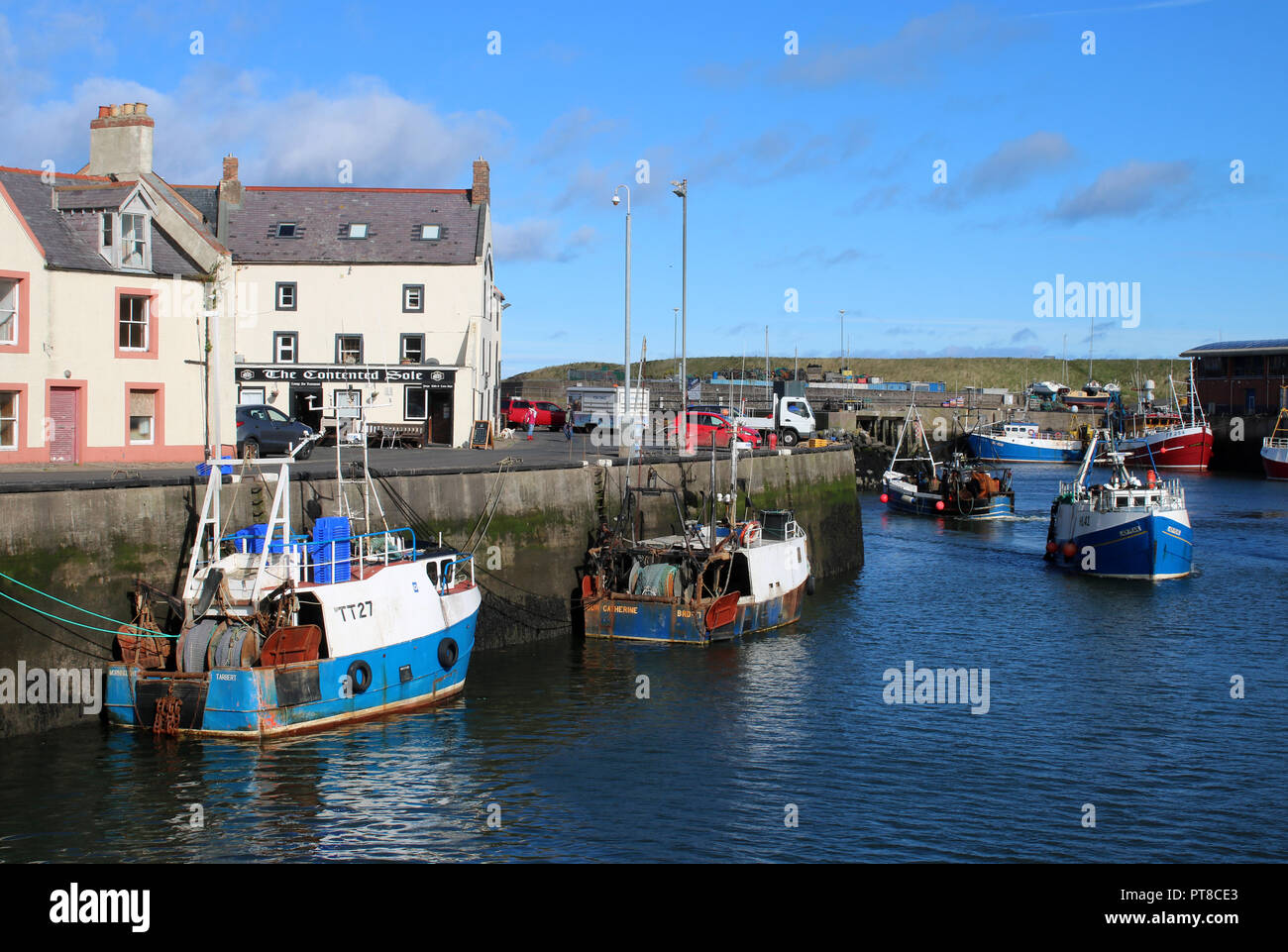 Blick auf die Fischerboote in den Hafen von Eyemouth, Borders, Schottland mit Gebäuden am Kai einschließlich der Wal Hotels und der Zufriedene Sohle. Stockfoto