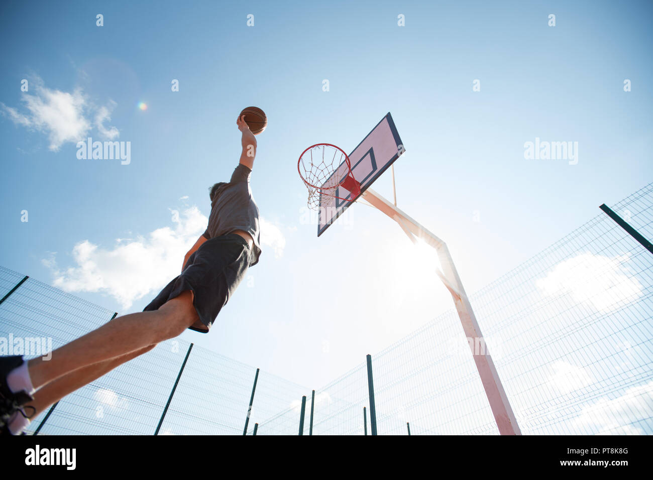 Weitwinkel Porträt der jungen Sportler shooting Slam Dunk im Basketball Court, Kopieren im freien Raum Stockfoto