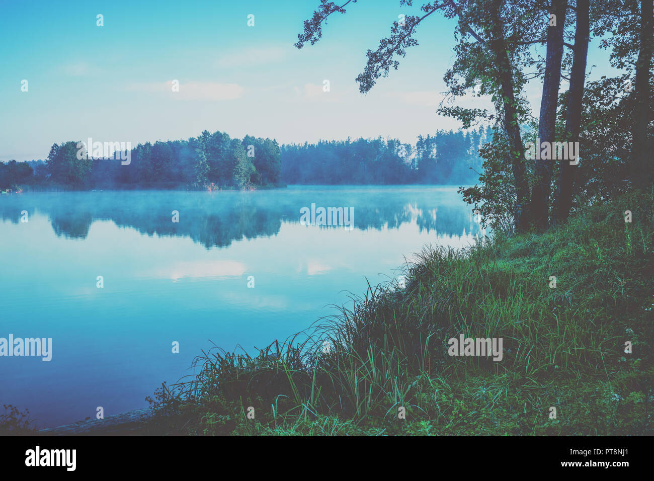 Am frühen Morgen, Sonnenaufgang über dem See. Landwirtschaftliche Landschaft Stockfoto