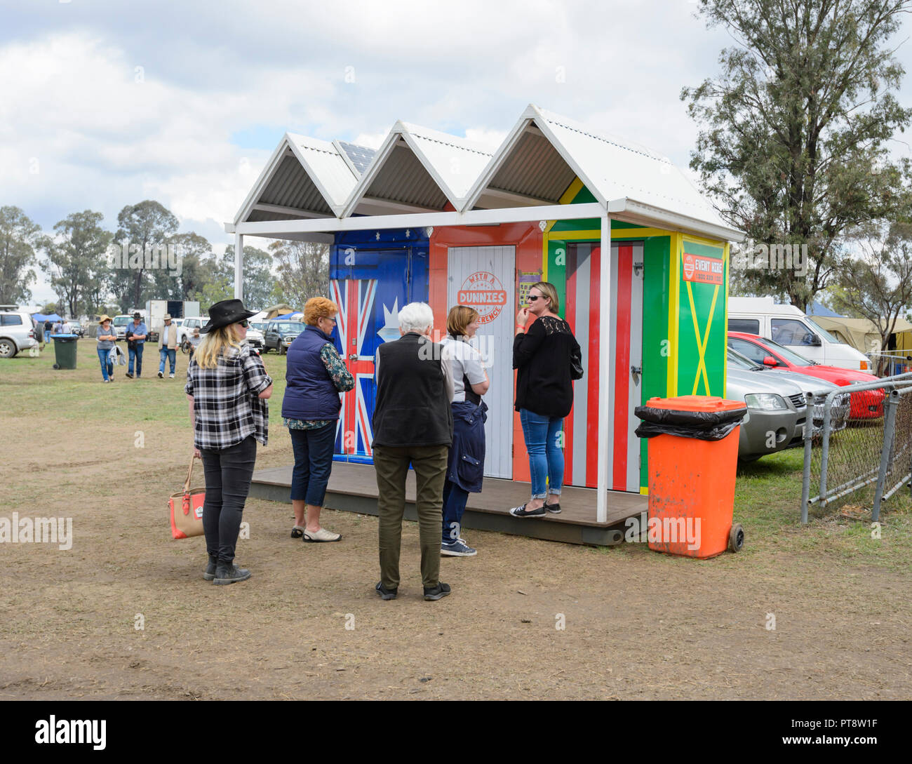 Meine Damen Schlange an ungewöhnlichen öffentlichen Toiletten oder dunnies auf der Suche nach Strand Hütten, Australische Camp Backofen Festival 2018, Millmerran, südlichen Queensland, Stockfoto