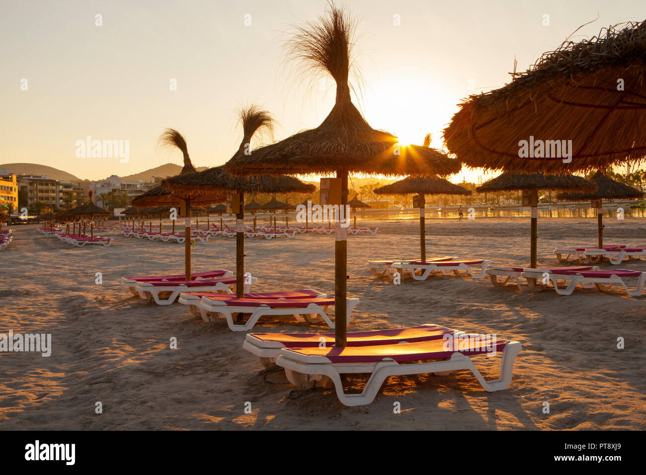 Leere Stühle und Stroh Sonnenschirme am Strand von Alcudia auf Mallorca bei  Sonnenaufgang Stockfotografie - Alamy