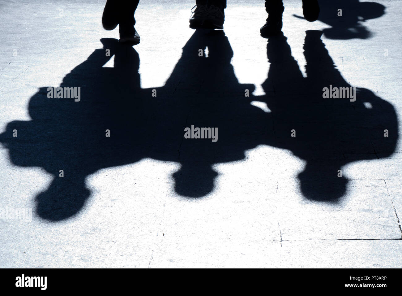 Verschwommene Silhouetten und Schatten der drei man walking city street in der Nacht Stockfoto