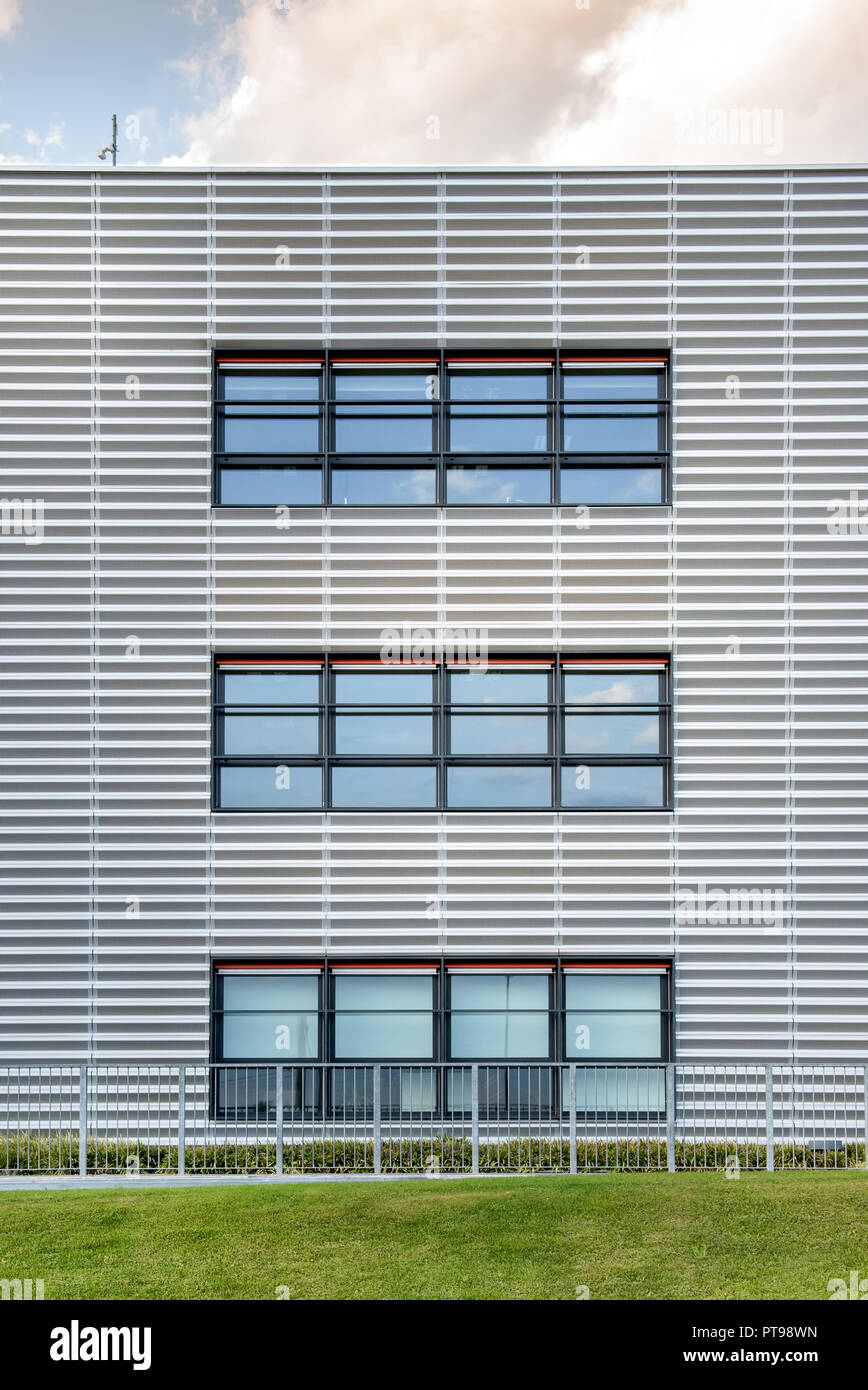 Symmetrische Ansicht eines modernen kommerziellen Gebäude mit drei großen breiten Fenstern und einem grünen Rasen vor Stockfoto