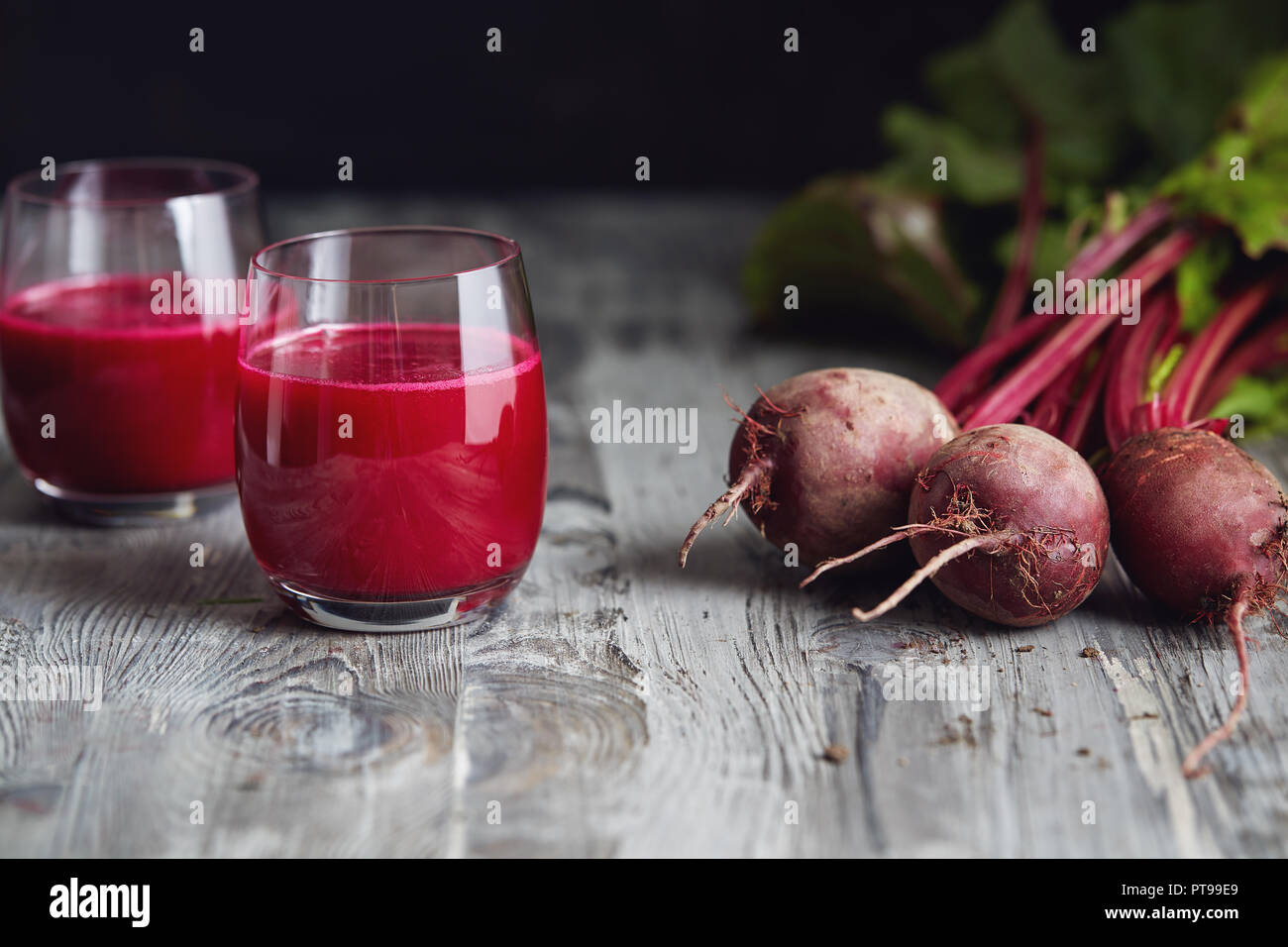 Detox Saft mit frisch gepflückten Bündel von Rote Bete. Frische rote Rüben auf einem Holztisch. Stockfoto