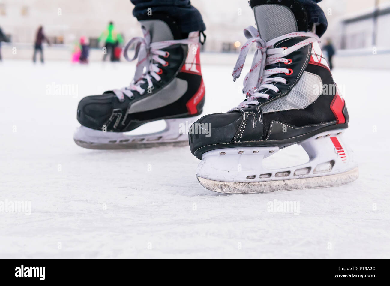 Man hockey Skates auf Eis Hintergrund. Leute Eislaufen auf der Eisbahn. Wochenende Unterhaltung im Winter im Freien. Stockfoto