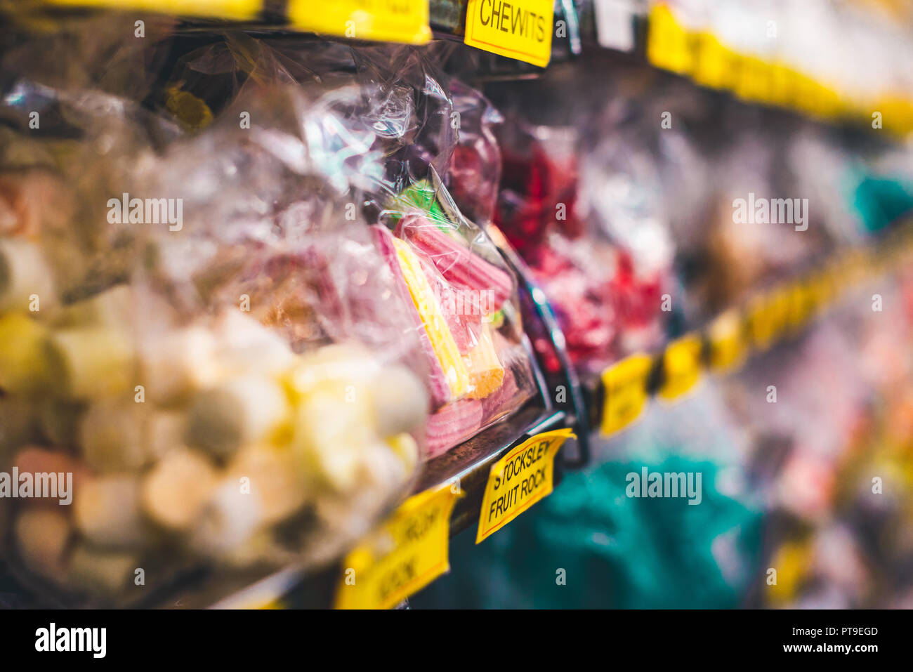 Lecker, roten und gelben Bonbons und Süßigkeiten in einem Wrapper auf einem Regal eines Sweet Shop in Matlock, Großbritannien Stockfoto