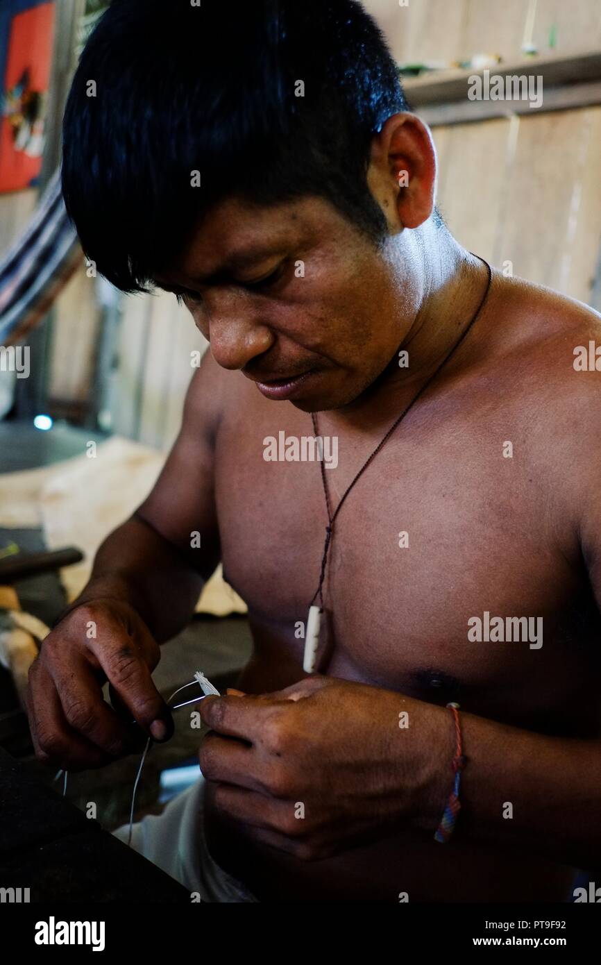 Die ticuna Indianerstämme die Nähte ein Baum Rinde Artefakt zusammen Stockfoto