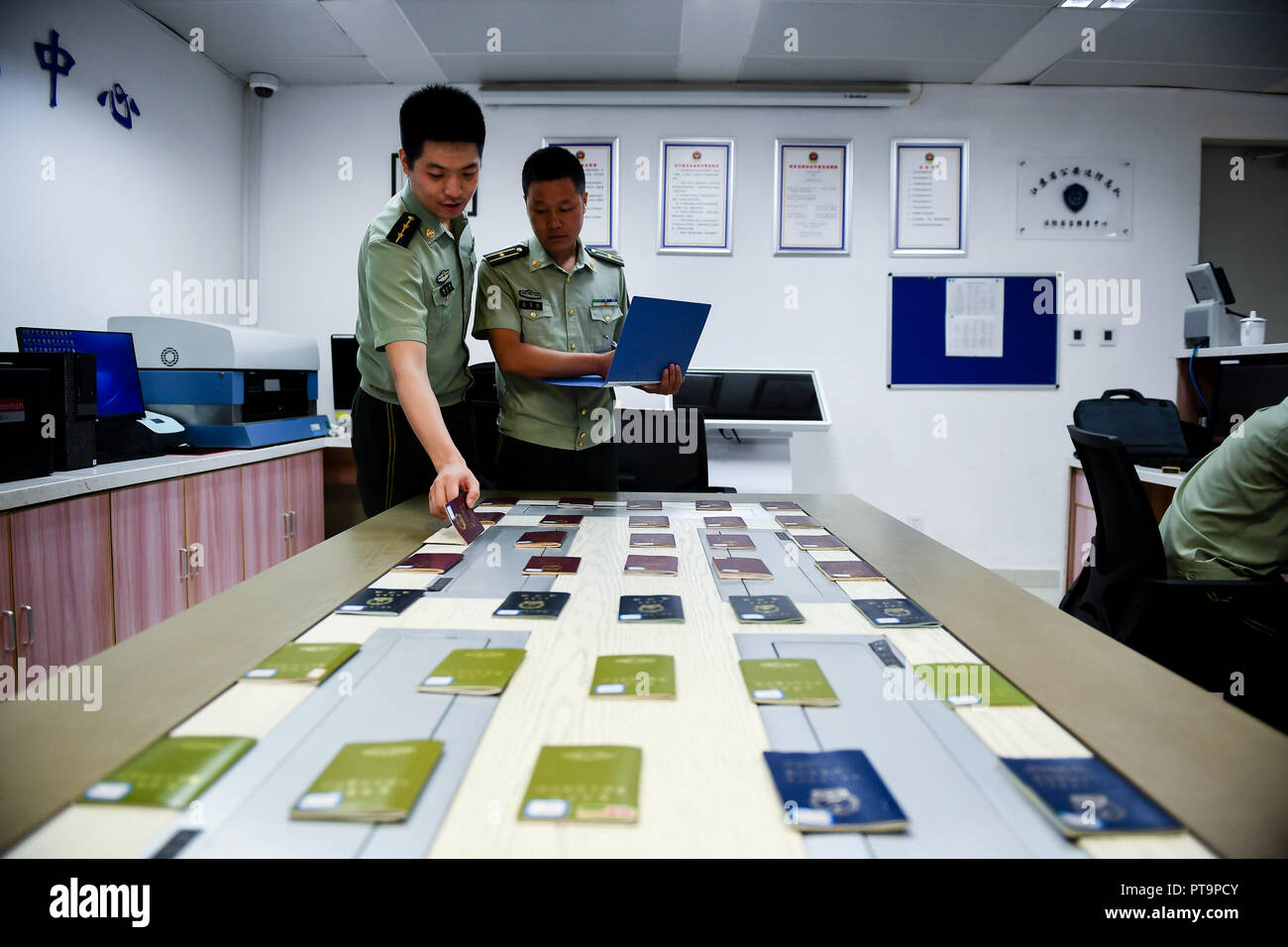 (181008) - NANJING, Oktober 8, 2018 (Xinhua) - Wang Zhiguo (R) arbeitet bei einer Inspektion von Nanjing Lukou Flughafen Nanjing, die Hauptstadt der ostchinesischen Provinz Jiangsu, Aug 7, 2018. Wang Jicai, der Chef der Miliz post auf kaishan Insel in der Provinz Jiangsu, anfing, auf der Insel im Gelben Meer mit seiner Frau im Jahr 1986. Er starb plötzlicher Krankheit während auf Aufgabe im Juli 2018 im Alter von 58. Wang Zhiguo, Sohn von Wang Jicai, wurde eine Grenze Verteidigung Polizist nach seinem Abschluss von der Nanjing Universität für Luft- und Raumfahrt im Jahr 2013. Er hatte Bee Stockfoto