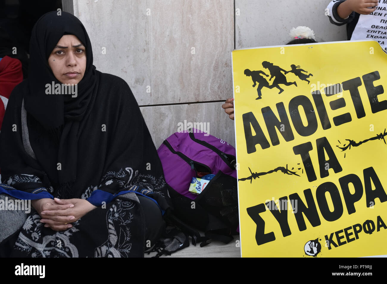 Piräus, Griechenland. 8. Okt 2018. Ein flüchtling Frau sitzt neben einem Plakat mit der Aufschrift "Offene Grenzen" gegen die schlechten Lebensbedingungen bei Malakasa Camp vor dem Ministerium der Migrationspolitik in Piräus, Griechenland protestieren. Credit: Nicolas Koutsokostas/Alamy Leben Nachrichten. Stockfoto