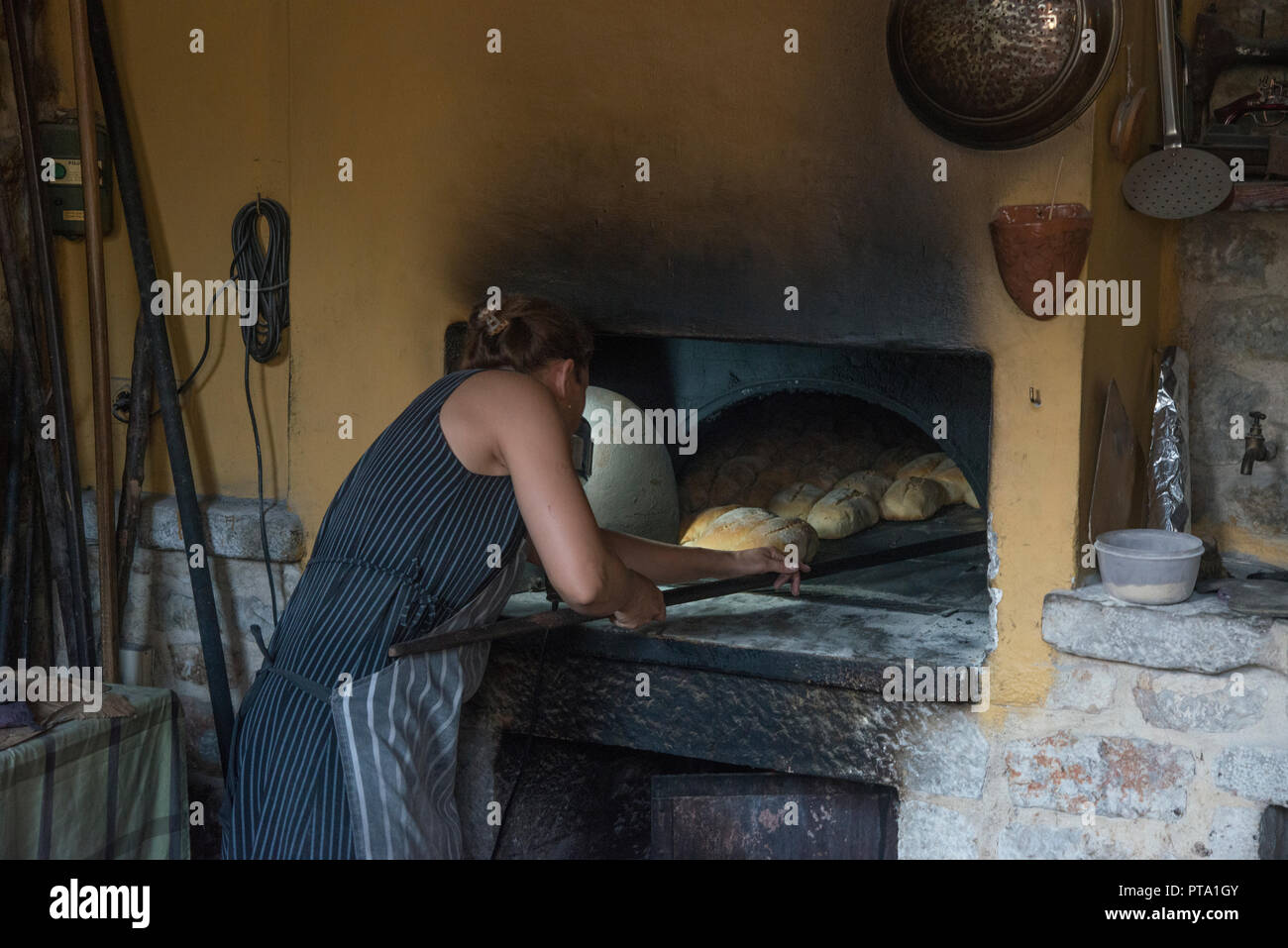 Frau Bäcker Brot backen im alten Stil Backofen Stockfoto