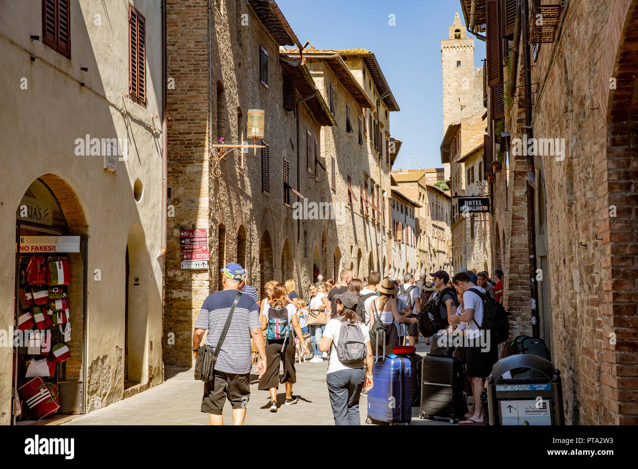 Touristen zu Fuß durch die mittelalterlichen Stadt San Gimignano in der Toskana, Italien, Europa Stockfoto
